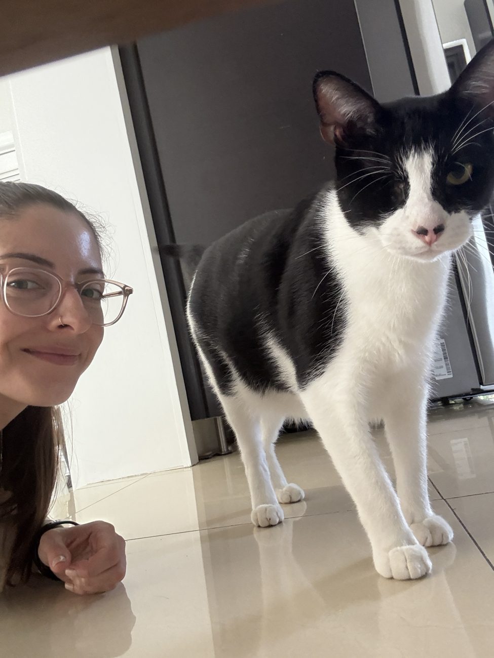 Elizabeth smiling beside a black and white cat